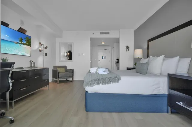 a bedroom with a bed and a flat screen tv