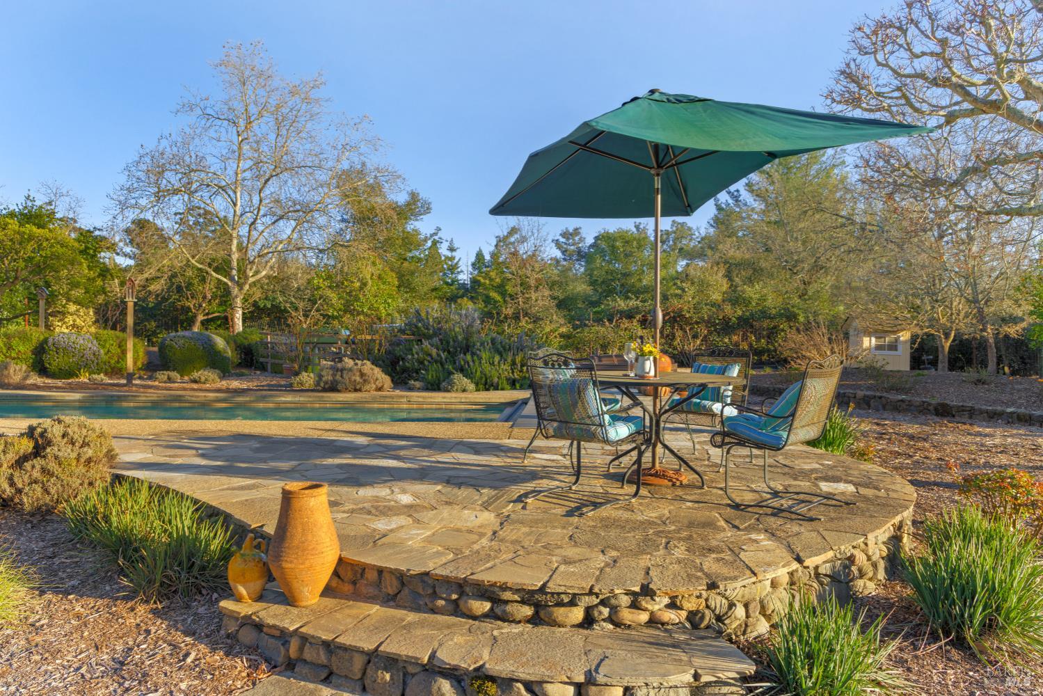 1245 Castle Road Sonoma, CA 95476 - Photo 34 of 48 a view of a swimming pool with a table and chairs under an umbrella
