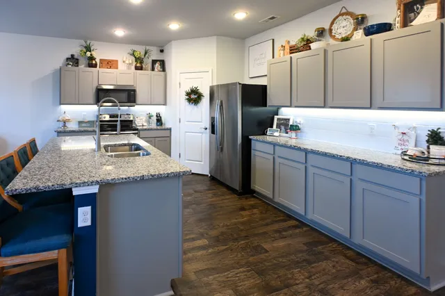 a kitchen with stainless steel appliances granite countertop a refrigerator and a sink