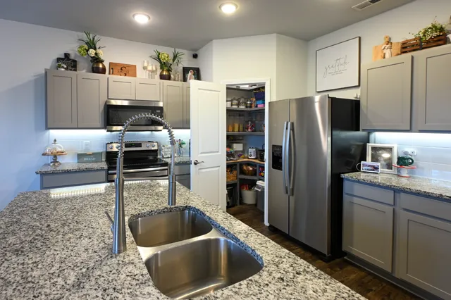 a living room with stainless steel appliances furniture and a wooden floor