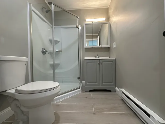 a bathroom with a granite countertop toilet sink and shower