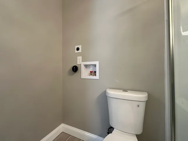a white toilet sitting next to a white walls