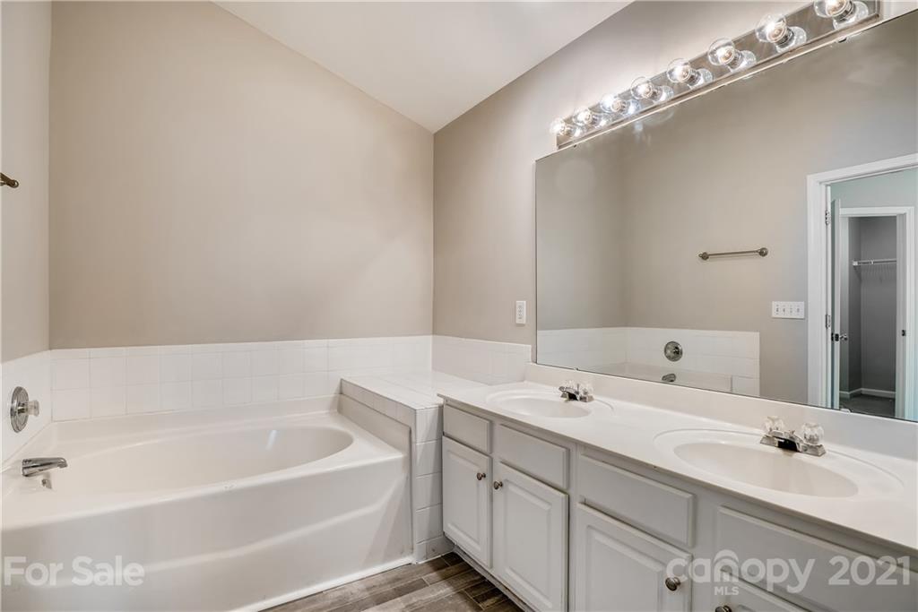 3115 Tanzanite Circle Fort Mill, SC 29708 - Photo 18 of 33 a bathroom with a tub a double vanity sink and mirror