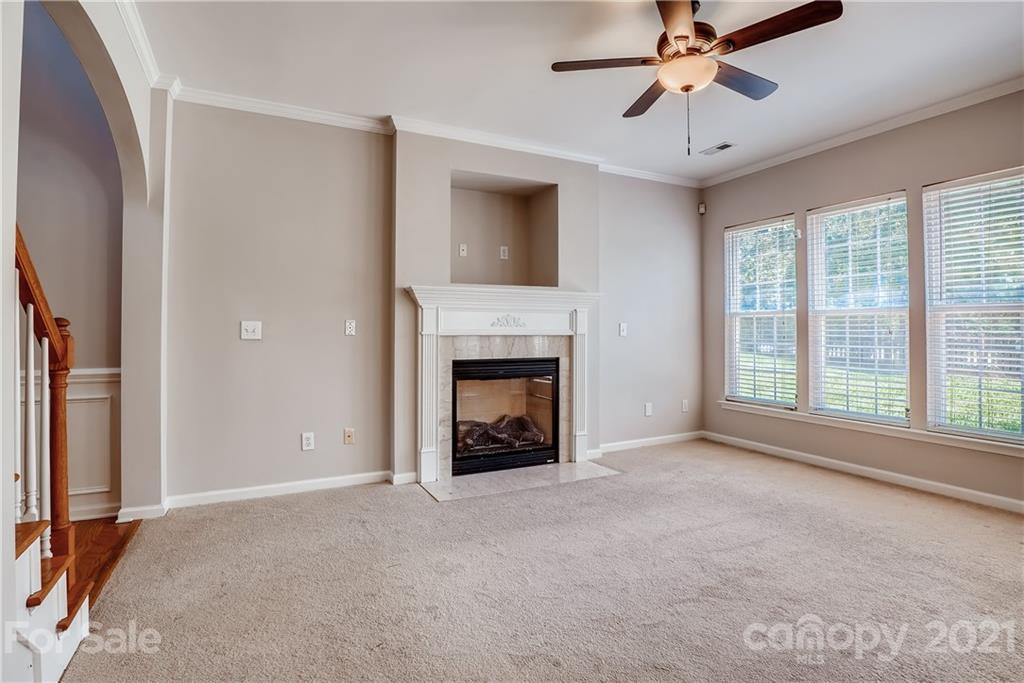 3115 Tanzanite Circle Fort Mill, SC 29708 - Photo 6 of 33 a view of an empty room with chandelier fan and fire place