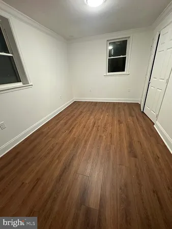 a view of a room with wooden floor and hallway