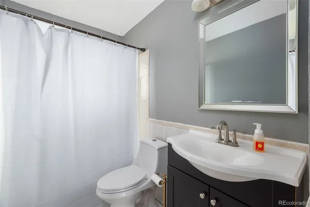 a bathroom with a sink a toilet and shower curtain