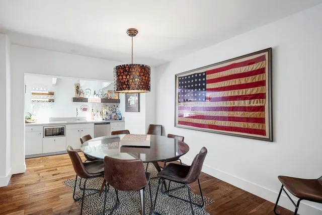 a kitchen with a stove a sink and wooden floor