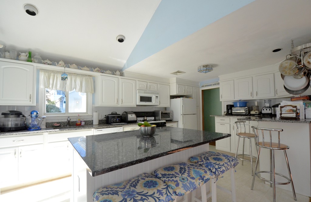 96 Doty Street Waltham, MA 02452 - Photo 2 of 15 a kitchen with stainless steel appliances kitchen island granite countertop a sink and cabinets