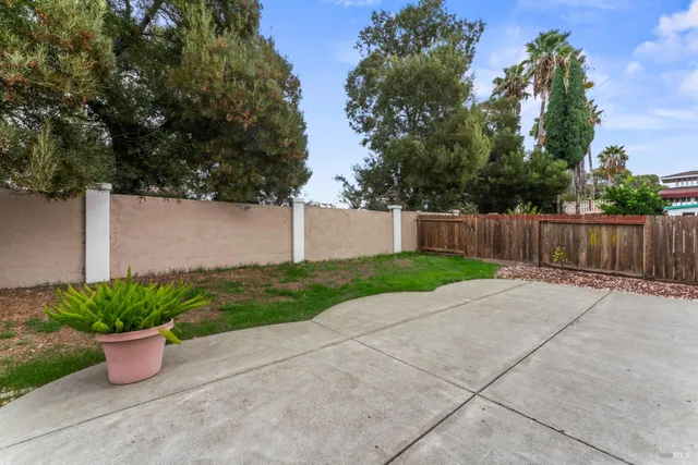 a view of a house with a yard and large tree