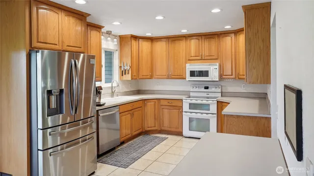 a kitchen with stainless steel appliances granite countertop a refrigerator stove microwave and sink