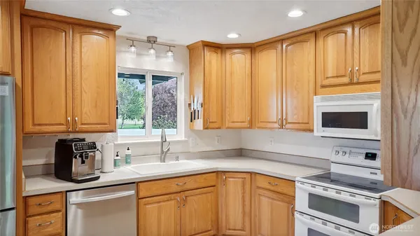 a kitchen with stainless steel appliances a sink cabinets and a window