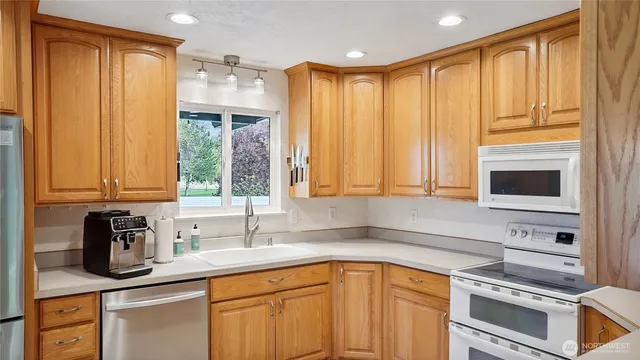 a kitchen with stainless steel appliances a sink cabinets and a window