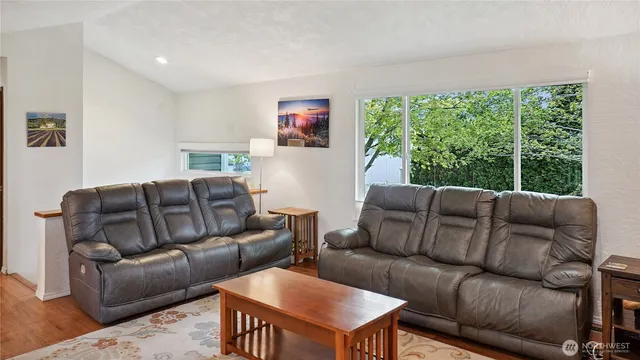 a living room with furniture a large window and a flat screen tv