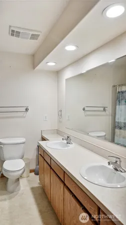 a bathroom with a sink a toilet and mirror