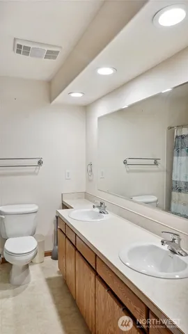 a bathroom with a sink a toilet and mirror