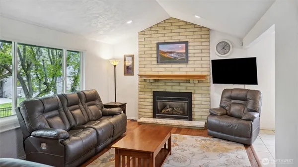 a living room with furniture a large window and a fireplace