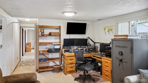 a view of a livingroom with workspace and a flat screen tv