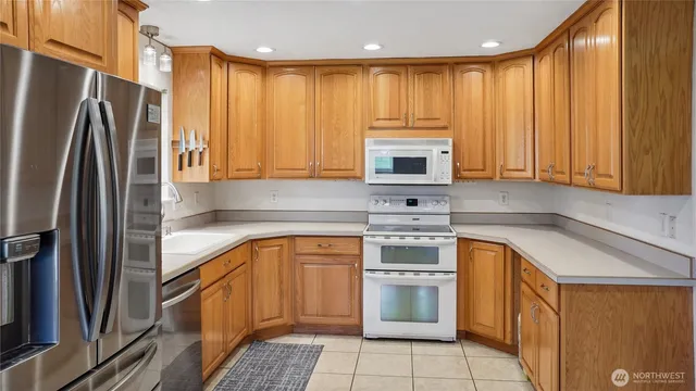 a kitchen with stainless steel appliances granite countertop a refrigerator sink and stove