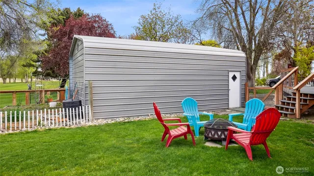 a view of backyard with chairs and a fence