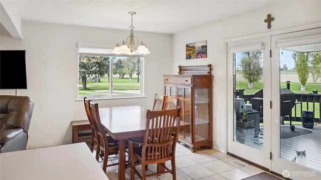 a dining room with furniture a chandelier and window