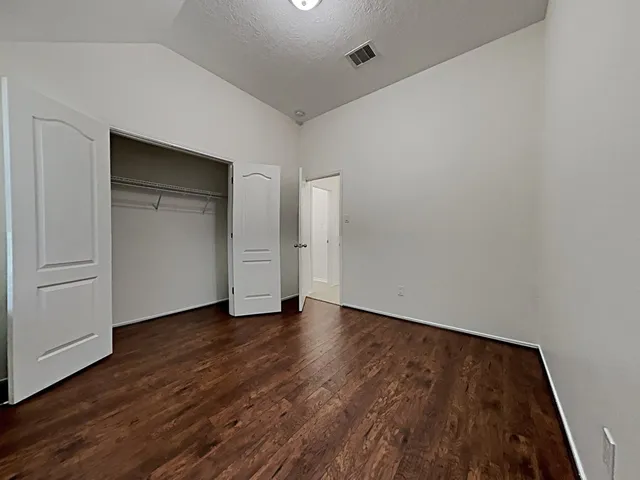 an empty room with wooden floor & closet