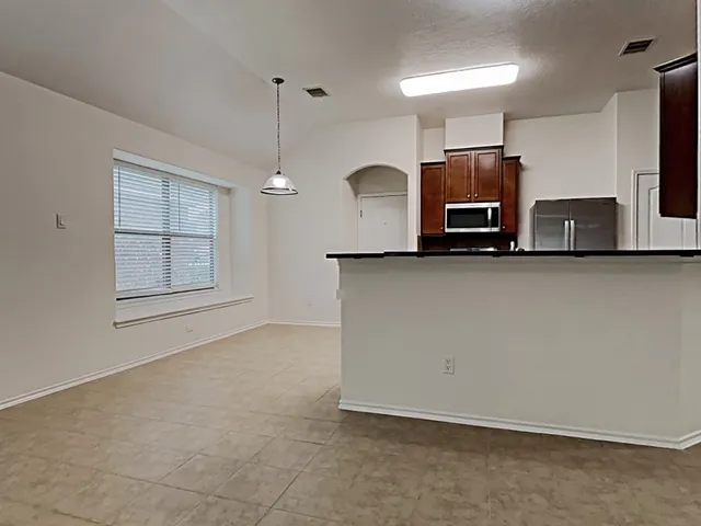 a kitchen with stainless steel appliances a microwave a sink and a refrigerator