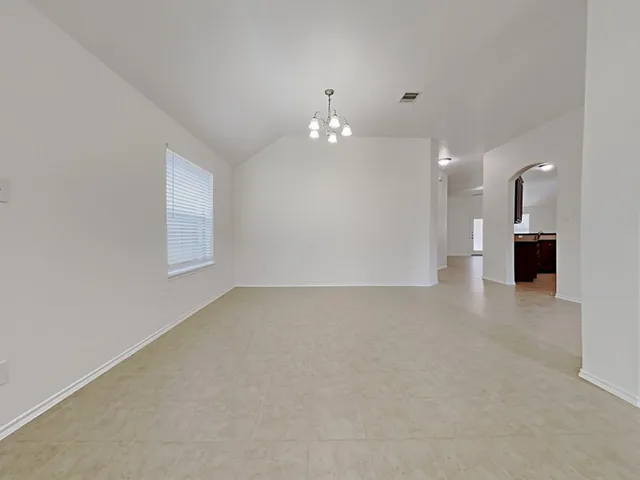 an empty room with a kitchen view and a window