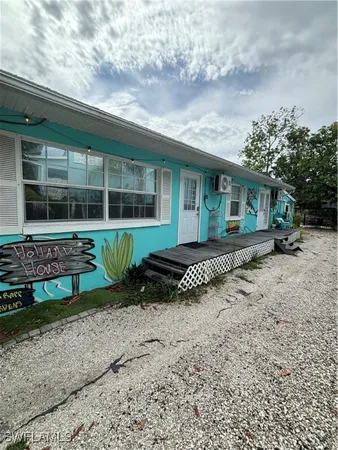 a front view of a house with a yard and potted plants