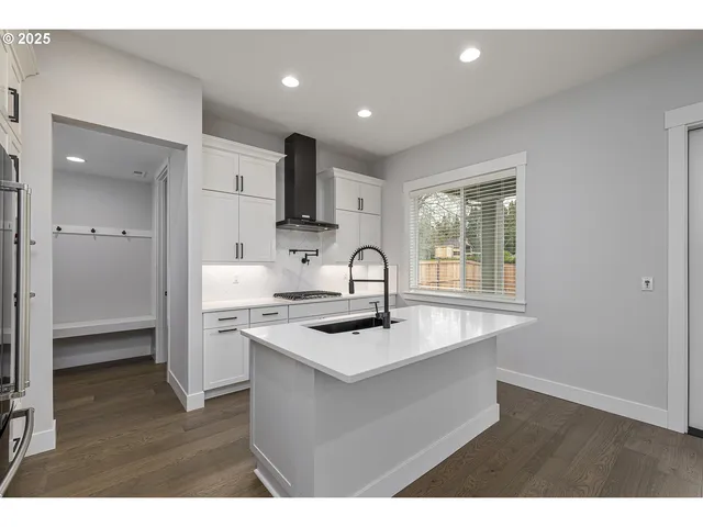 a kitchen with kitchen island stainless steel appliances a sink stove and cabinets