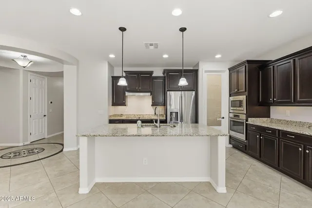 a kitchen with stainless steel appliances granite countertop a refrigerator and a sink