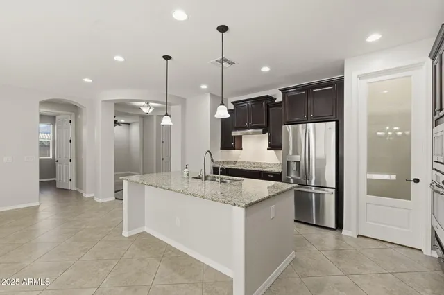 a kitchen with a sink a counter space and a chandelier