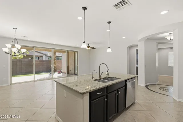 a kitchen with stainless steel appliances granite countertop a sink a stove and a wooden floor
