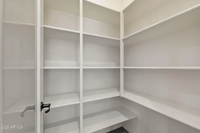 an empty room with a window and a ceiling fan