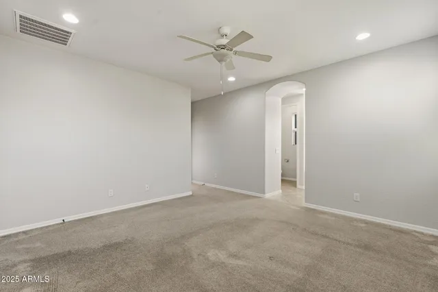 an empty room with closet and a ceiling fan