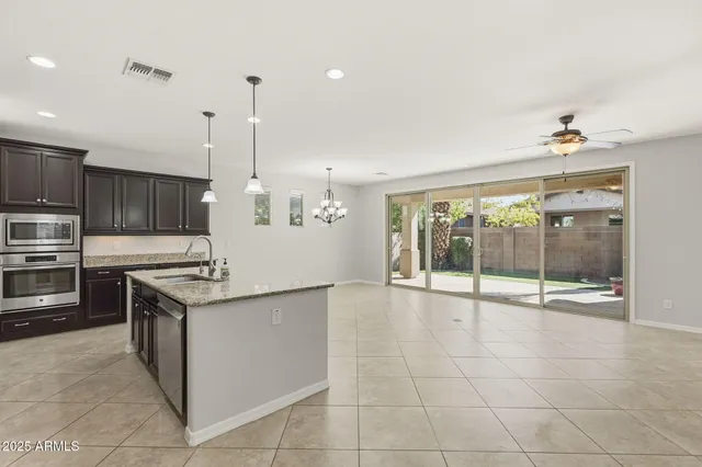 a kitchen with stainless steel appliances granite countertop a sink a stove and a wooden floor