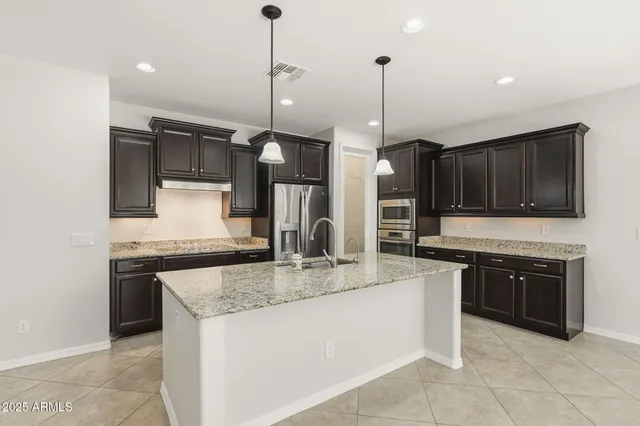 a large kitchen with kitchen island a large counter space appliances and cabinets