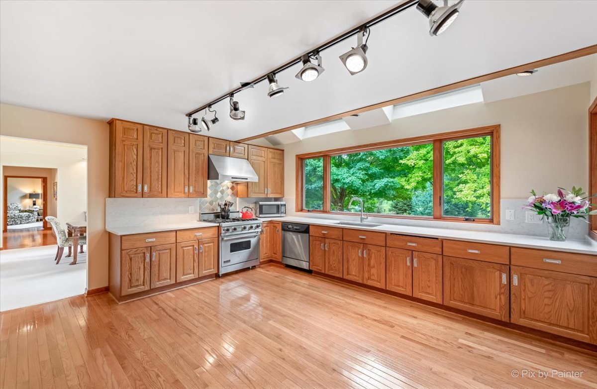 245 Perth Road Cary, IL 60013 - Photo 14 of 61 a large kitchen with stainless steel appliances granite countertop a large window a sink and cabinets