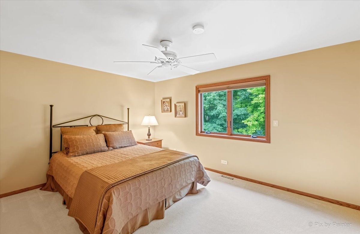 245 Perth Road Cary, IL 60013 - Photo 31 of 61 a bedroom with a large bed and a chandelier