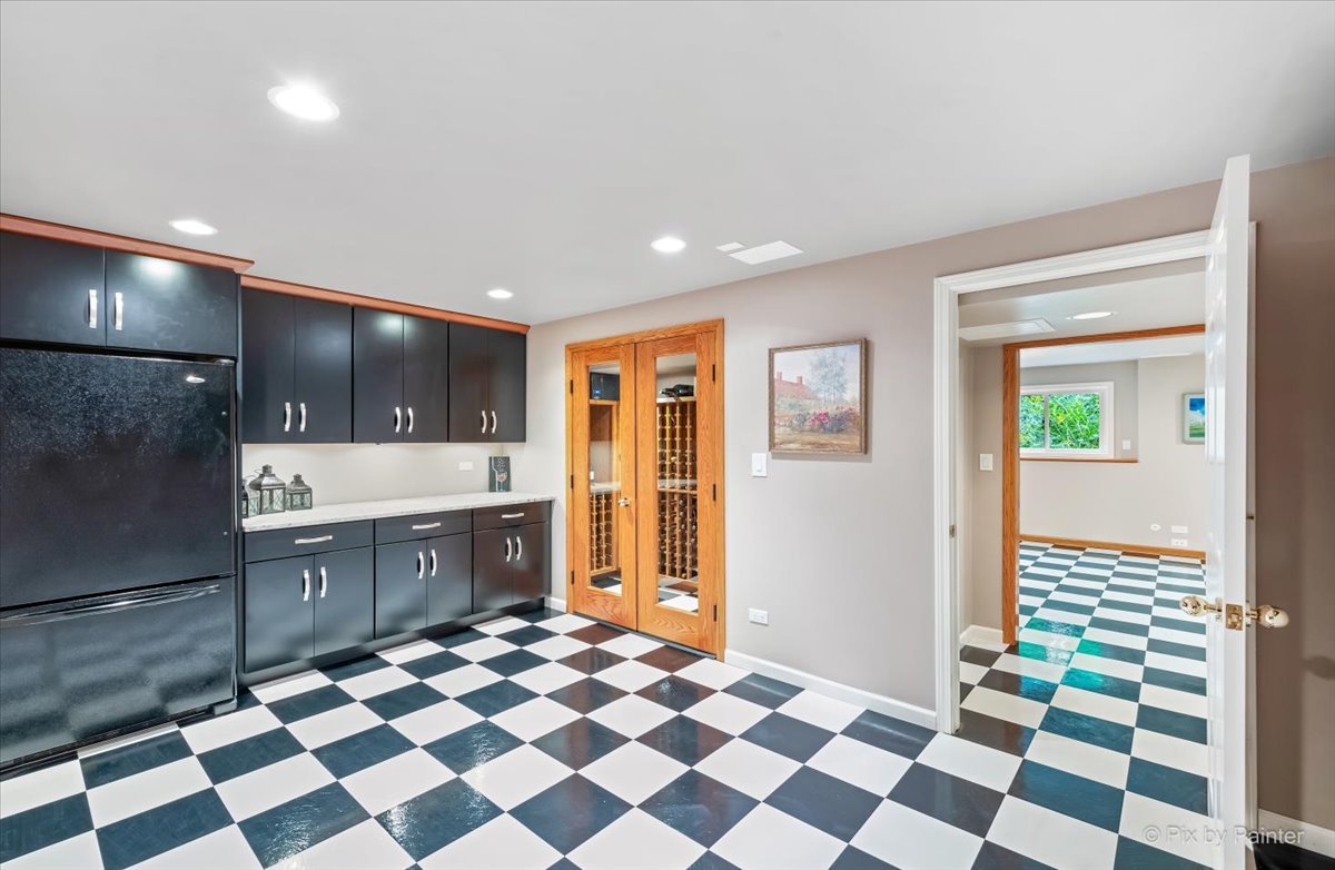 245 Perth Road Cary, IL 60013 - Photo 38 of 61 a kitchen with a checkered floor and white cabinets