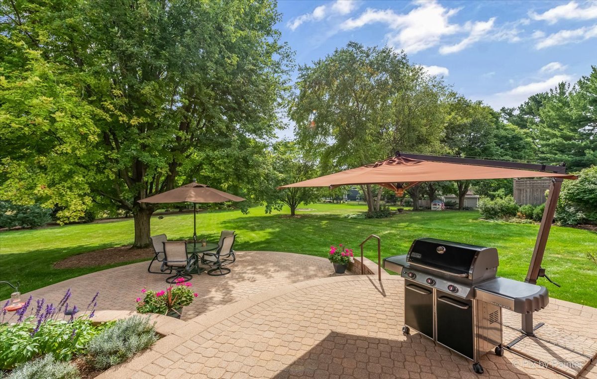 245 Perth Road Cary, IL 60013 - Photo 49 of 61 a view of a garden with a table and chairs under an umbrella