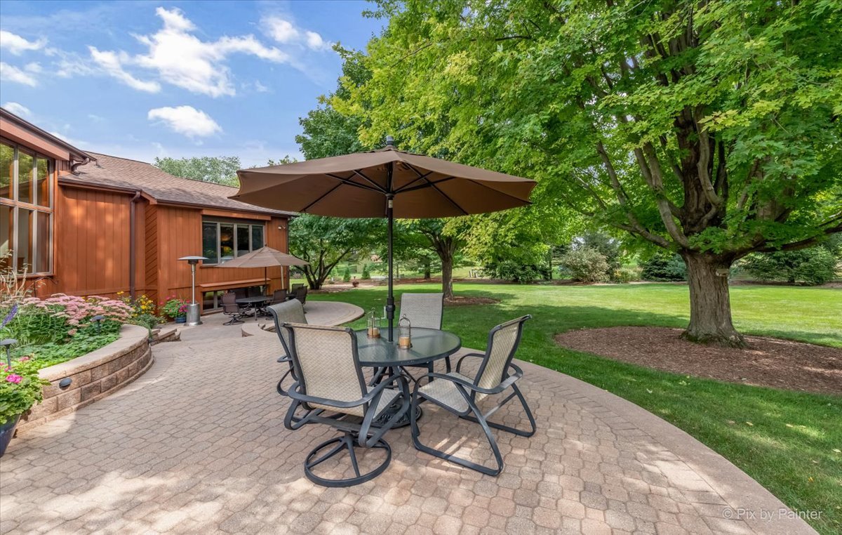 245 Perth Road Cary, IL 60013 - Photo 51 of 61 a view of a patio with table and chairs under an umbrella