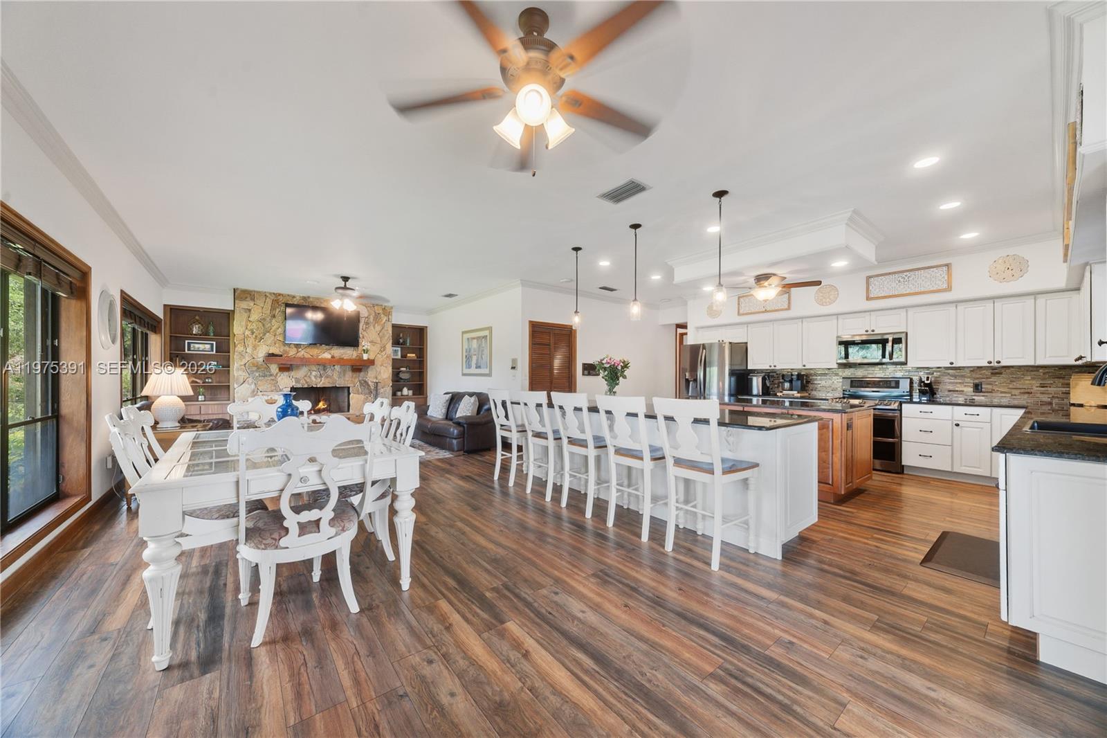1872 Southeast Colony Way Jupiter, FL 33478 - Photo 25 of 26 a kitchen with stainless steel appliances kitchen island granite countertop a table chairs and a stove