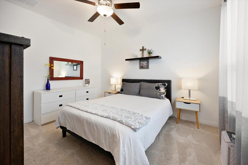 528 Poplar Street Princeton, TX 75407 - Photo 16 of 39 a bedroom with a bed and a chandelier