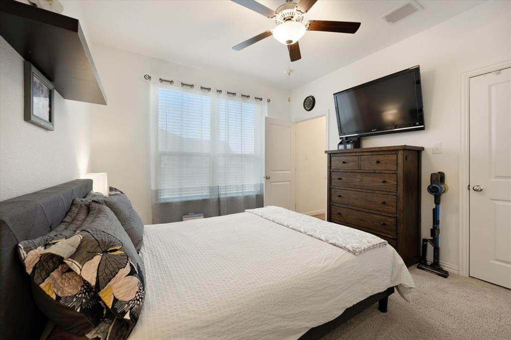 528 Poplar Street Princeton, TX 75407 - Photo 17 of 39 a bedroom with a bed and a flat tv screen on the dresser