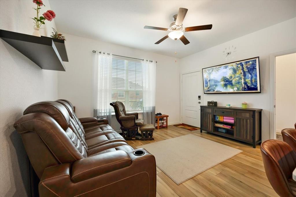 528 Poplar Street Princeton, TX 75407 - Photo 18 of 39 a living room with furniture a flat screen tv and a fireplace