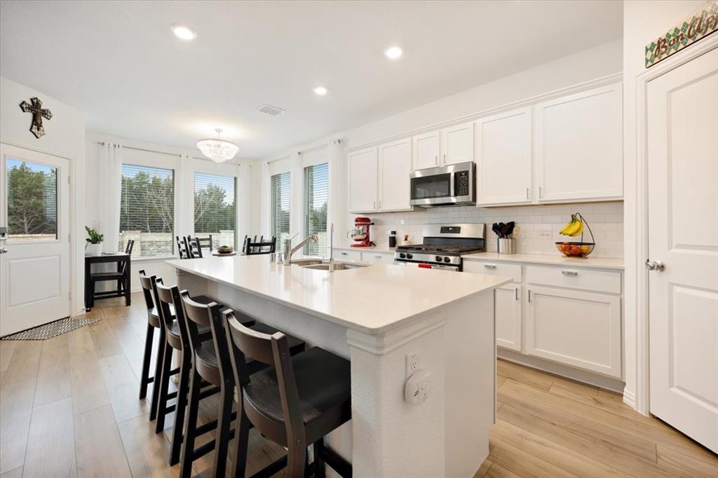 528 Poplar Street Princeton, TX 75407 - Photo 9 of 39 a kitchen with a table chairs refrigerator and cabinets