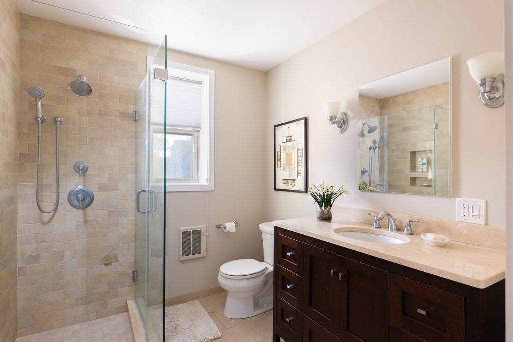 152 Harvard Street, Unit 4 Brookline, MA 02446 - Photo 14 of 26 a bathroom with a double vanity sink toilet mirror and shower