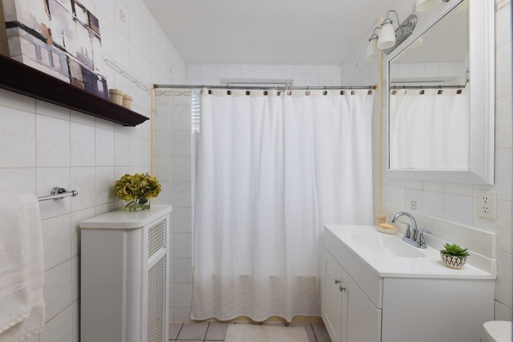 152 Harvard Street, Unit 4 Brookline, MA 02446 - Photo 15 of 26 a bathroom with a sink a toilet and shower