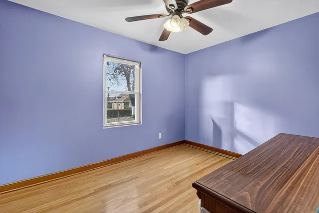 a view of an empty room with window and wooden floor