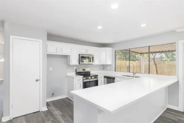 a large white kitchen with a stove a sink and dishwasher